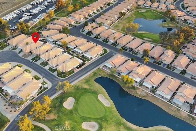 aerial view with golf course view, a water view, and a residential view