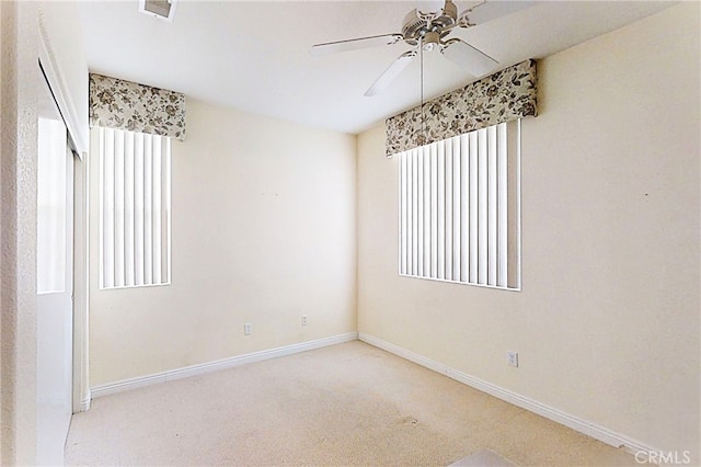 spare room featuring baseboards, carpet flooring, a wealth of natural light, and a ceiling fan