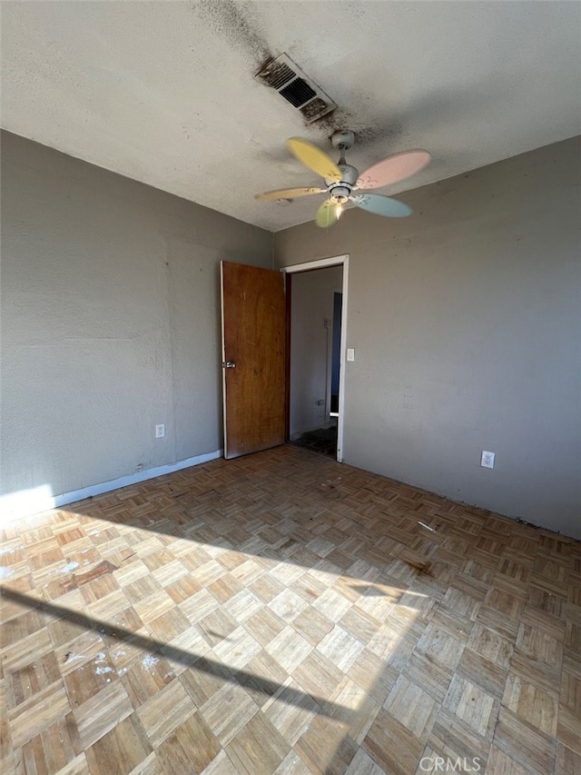 spare room featuring a ceiling fan, visible vents, and a textured ceiling