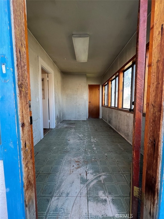 hall with tile patterned floors