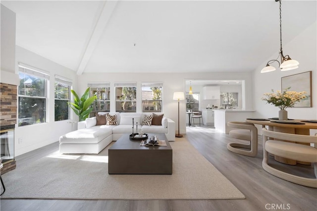 living area featuring high vaulted ceiling, light wood finished floors, and beamed ceiling