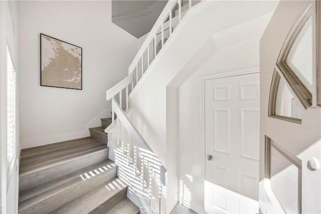 staircase with baseboards and wood finished floors