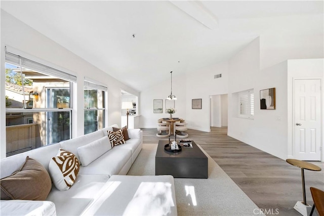 living room with high vaulted ceiling, beamed ceiling, wood finished floors, and visible vents