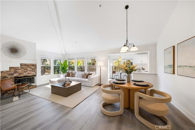 living area with lofted ceiling, a stone fireplace, and light wood-style flooring