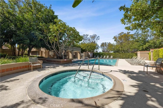 pool featuring a patio area, a hot tub, and fence