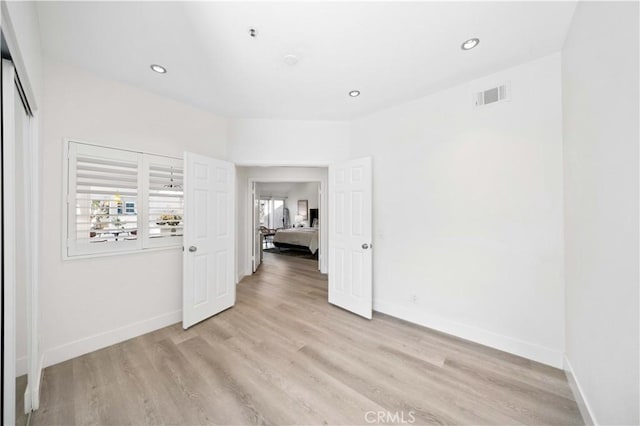 unfurnished room with light wood-type flooring, plenty of natural light, visible vents, and baseboards