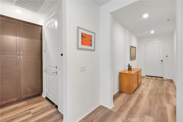 hall featuring recessed lighting, visible vents, light wood-style flooring, and baseboards