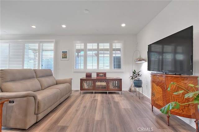 living room with plenty of natural light, wood finished floors, recessed lighting, and baseboards