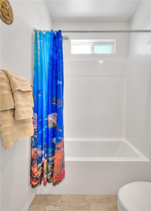 bathroom featuring shower / bathtub combination with curtain, toilet, and tile patterned flooring