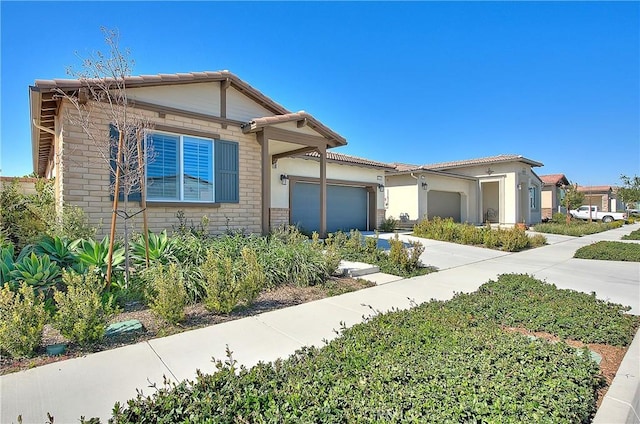 view of front of home with concrete driveway, an attached garage, and a tile roof