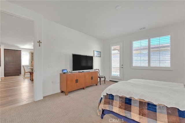 bedroom featuring light carpet, visible vents, and baseboards