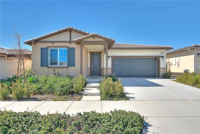 view of front of house featuring a tiled roof, an attached garage, driveway, and brick siding