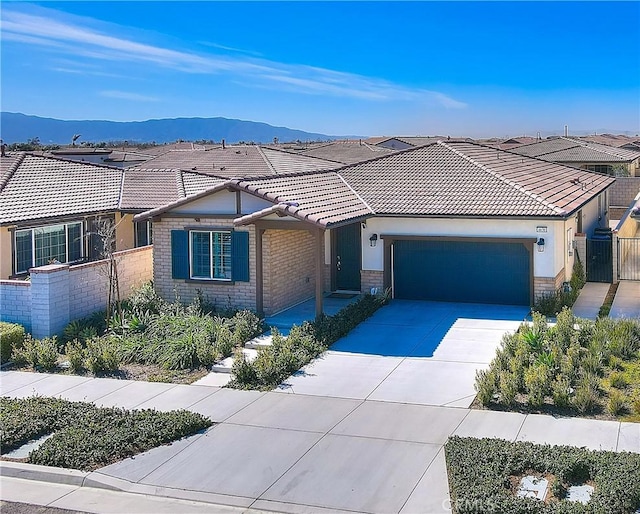 view of front of house with a garage, a tile roof, concrete driveway, and fence