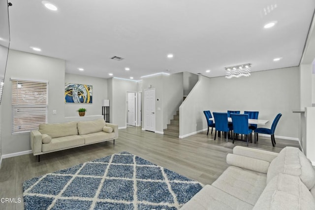 living room with visible vents, stairway, wood finished floors, and recessed lighting