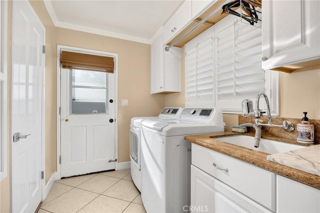 laundry area featuring crown molding, light tile patterned floors, cabinet space, washing machine and dryer, and a sink