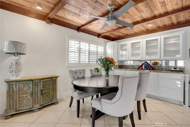 dining space with light tile patterned floors, a ceiling fan, wood ceiling, beamed ceiling, and baseboards