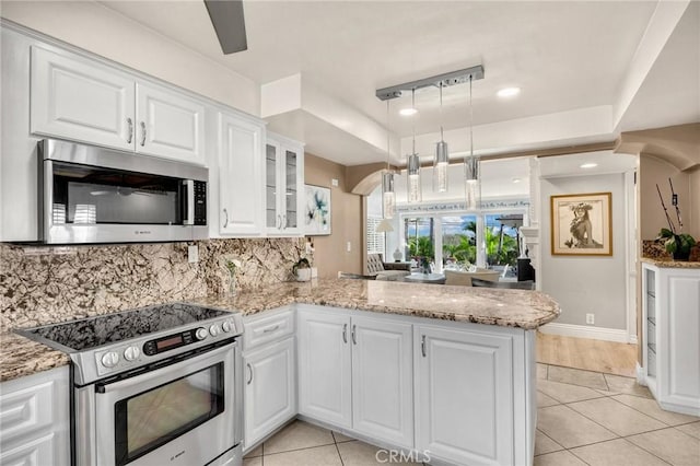 kitchen featuring tasteful backsplash, appliances with stainless steel finishes, glass insert cabinets, white cabinets, and a peninsula