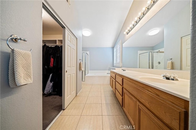 full bathroom featuring tile patterned flooring, a sink, a shower stall, and a bath