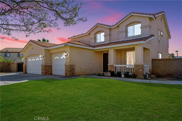 mediterranean / spanish-style house featuring a porch, stone siding, an attached garage, and concrete driveway