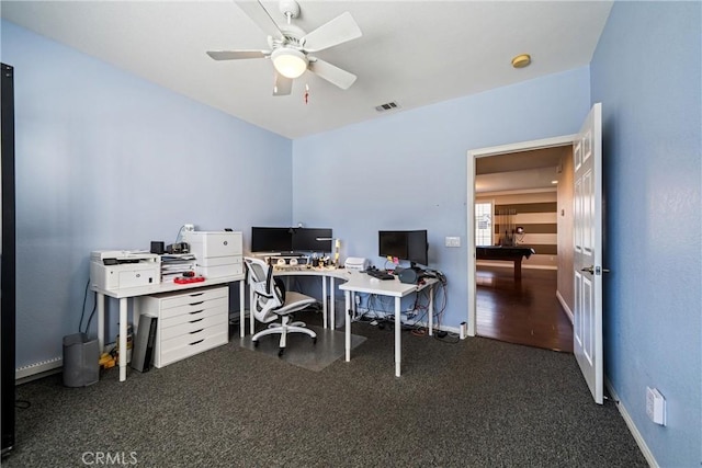 home office featuring baseboards, carpet, visible vents, and a ceiling fan