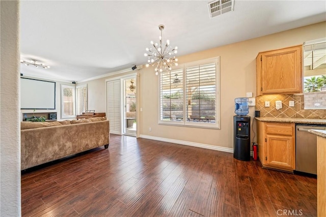 kitchen featuring dark wood-style floors, stainless steel dishwasher, visible vents, and tasteful backsplash