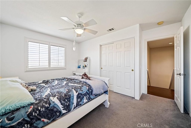 carpeted bedroom with a closet, visible vents, and a ceiling fan