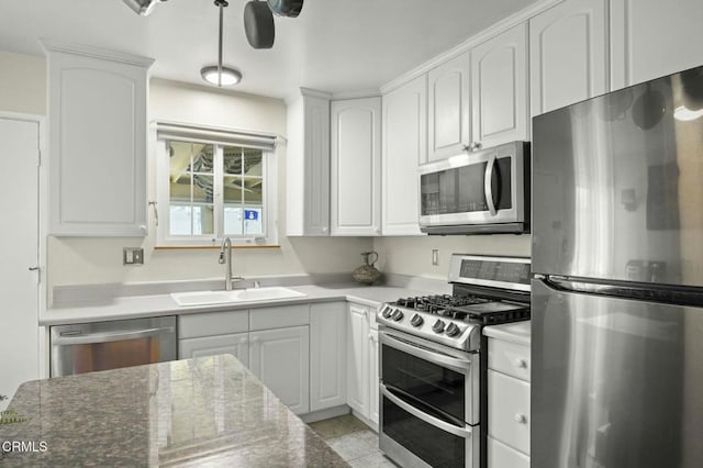 kitchen with a sink, appliances with stainless steel finishes, and white cabinetry