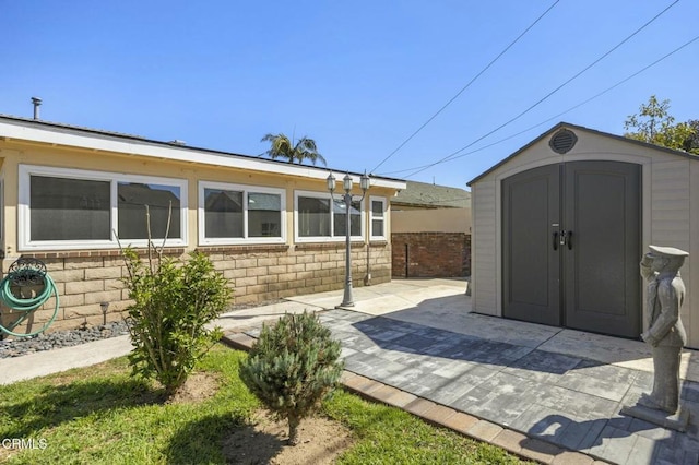 view of patio featuring a shed, an outdoor structure, and fence