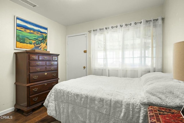 bedroom featuring dark wood-style floors, visible vents, and baseboards