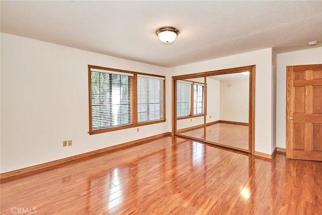 unfurnished room featuring light wood finished floors and baseboards