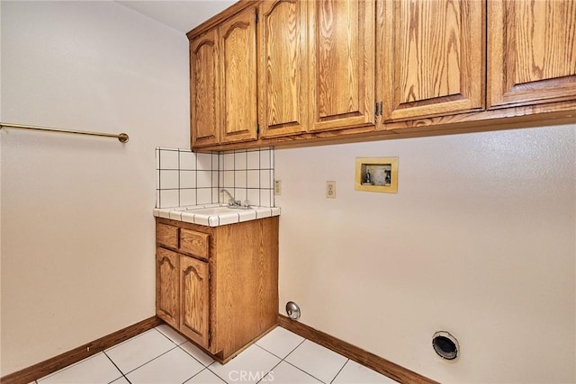 laundry room with light tile patterned floors, hookup for a washing machine, cabinet space, and baseboards