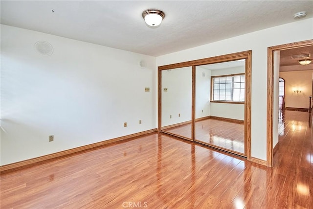 unfurnished bedroom with baseboards and light wood-style floors