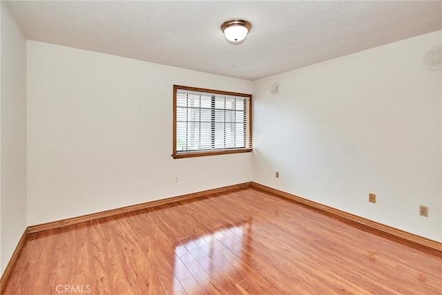 empty room with baseboards and light wood finished floors