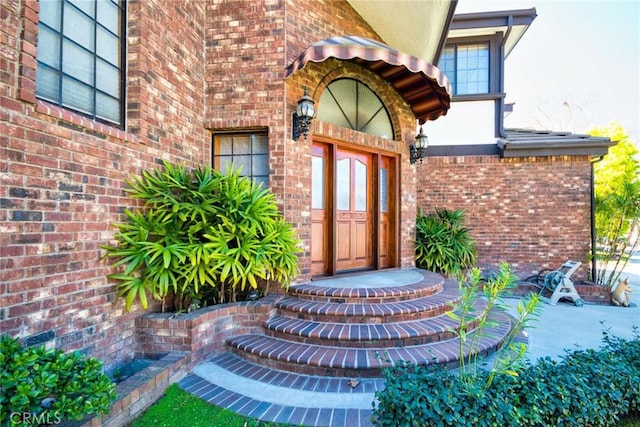 doorway to property with brick siding