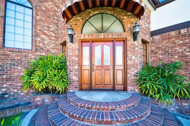 doorway to property with brick siding