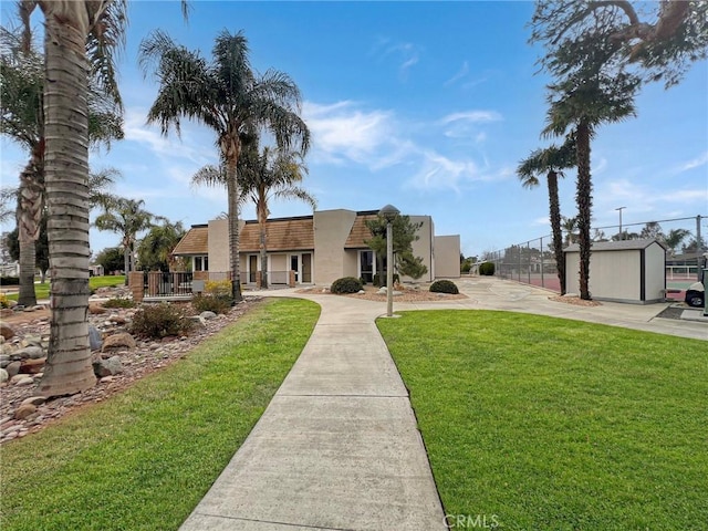 exterior space featuring a front lawn, fence, and stucco siding