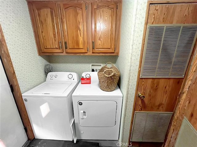 washroom with washer and clothes dryer and wallpapered walls