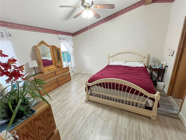 bedroom with ceiling fan, ornamental molding, wood finished floors, and baseboards