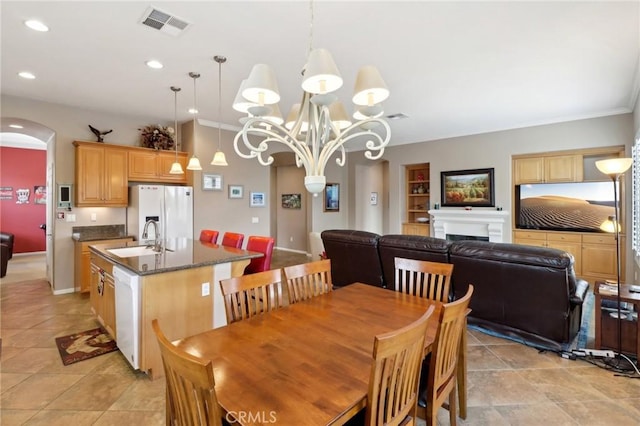 dining space with visible vents, a fireplace, arched walkways, and recessed lighting