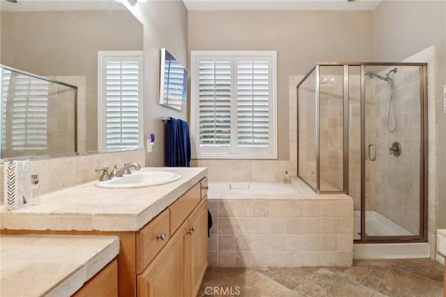 full bath featuring a garden tub, a shower stall, and vanity