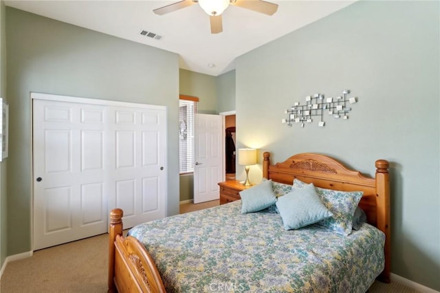 bedroom with a closet, light colored carpet, visible vents, a ceiling fan, and baseboards