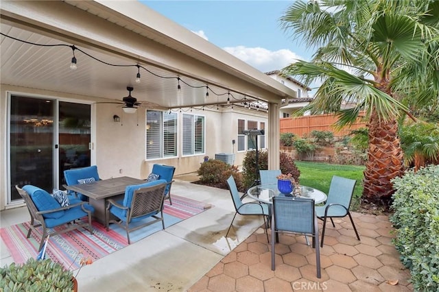 view of patio featuring outdoor dining area, ceiling fan, and fence