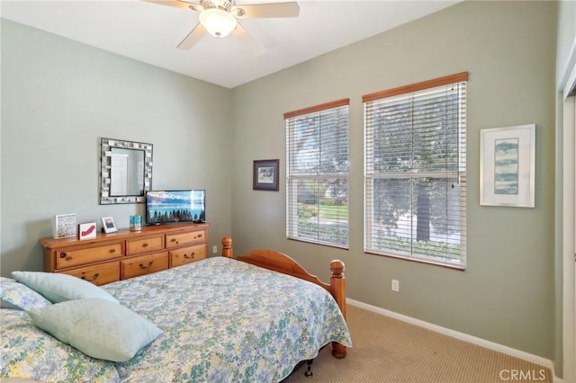 bedroom featuring ceiling fan, multiple windows, carpet, and baseboards