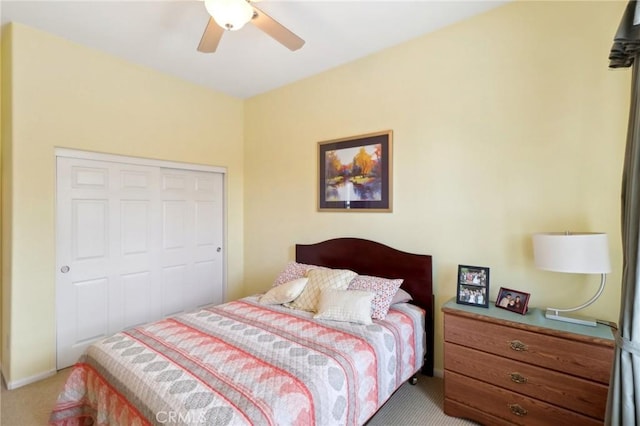 carpeted bedroom with ceiling fan and a closet