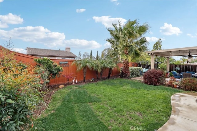 view of yard with a ceiling fan, a patio area, and a fenced backyard