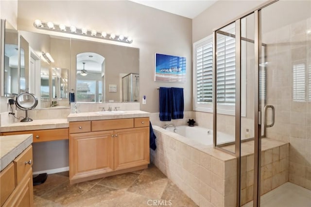 bathroom featuring a stall shower, a garden tub, ceiling fan, and vanity