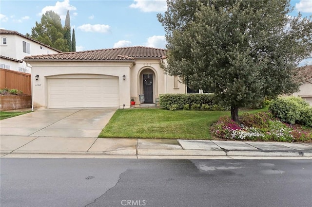 mediterranean / spanish-style house with driveway, a tiled roof, an attached garage, a front lawn, and stucco siding