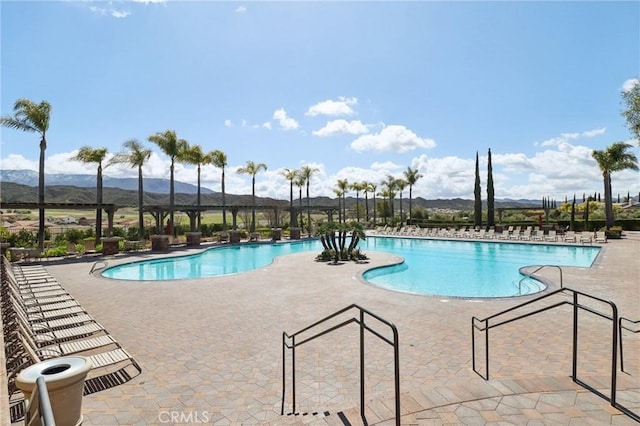 community pool featuring a mountain view and a patio