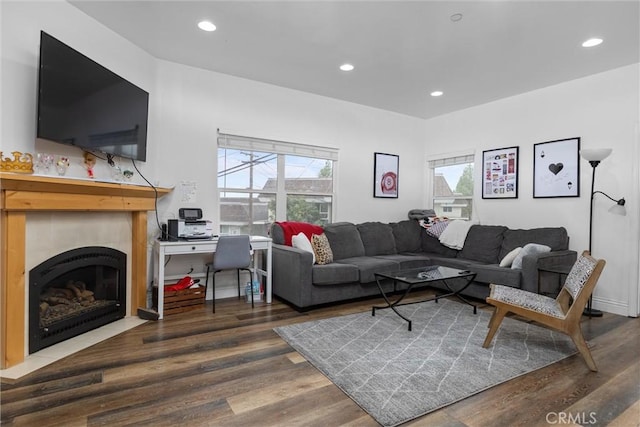 living area with a fireplace with flush hearth, recessed lighting, and wood finished floors