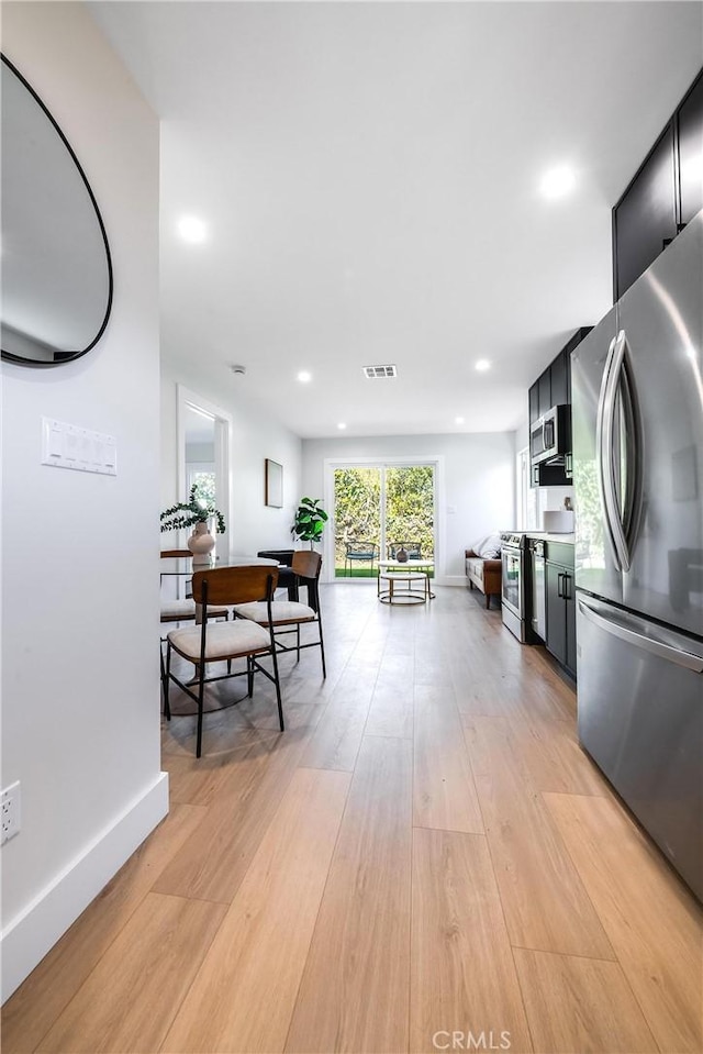 interior space featuring recessed lighting, visible vents, appliances with stainless steel finishes, light wood-style floors, and dark cabinets